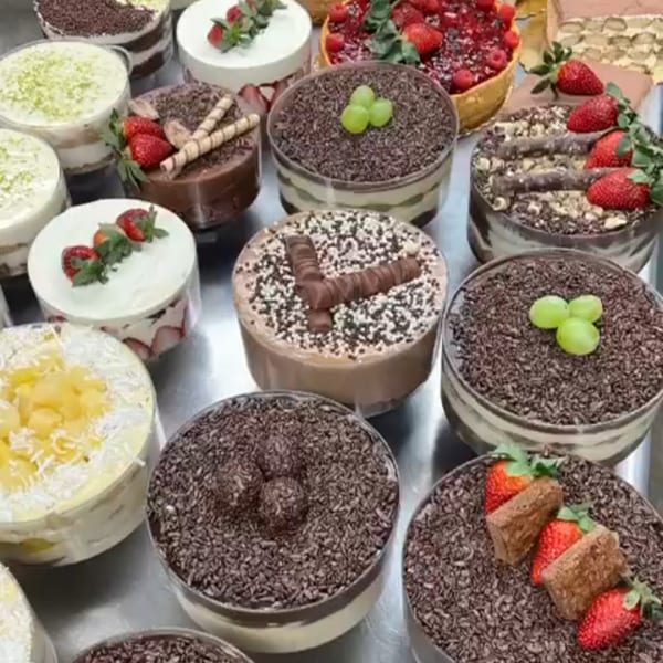 A variety of Brazilian desserts, including brigadeiro, passion fruit mousse, and strawberry tarts.