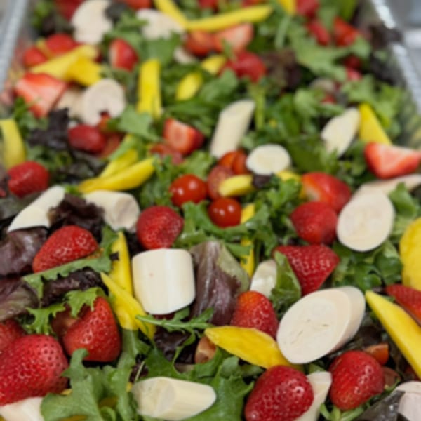 Brazilian salad with mixed greens, strawberries, mango, hearts of palm, and cherry tomatoes.