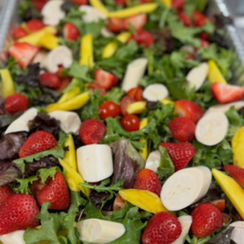 Brazilian salad with mixed greens, strawberries, mango, hearts of palm, and cherry tomatoes.