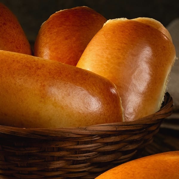 Golden-brown Brazilian cheese breads (pão de queijo) fill a rustic woven basket.
